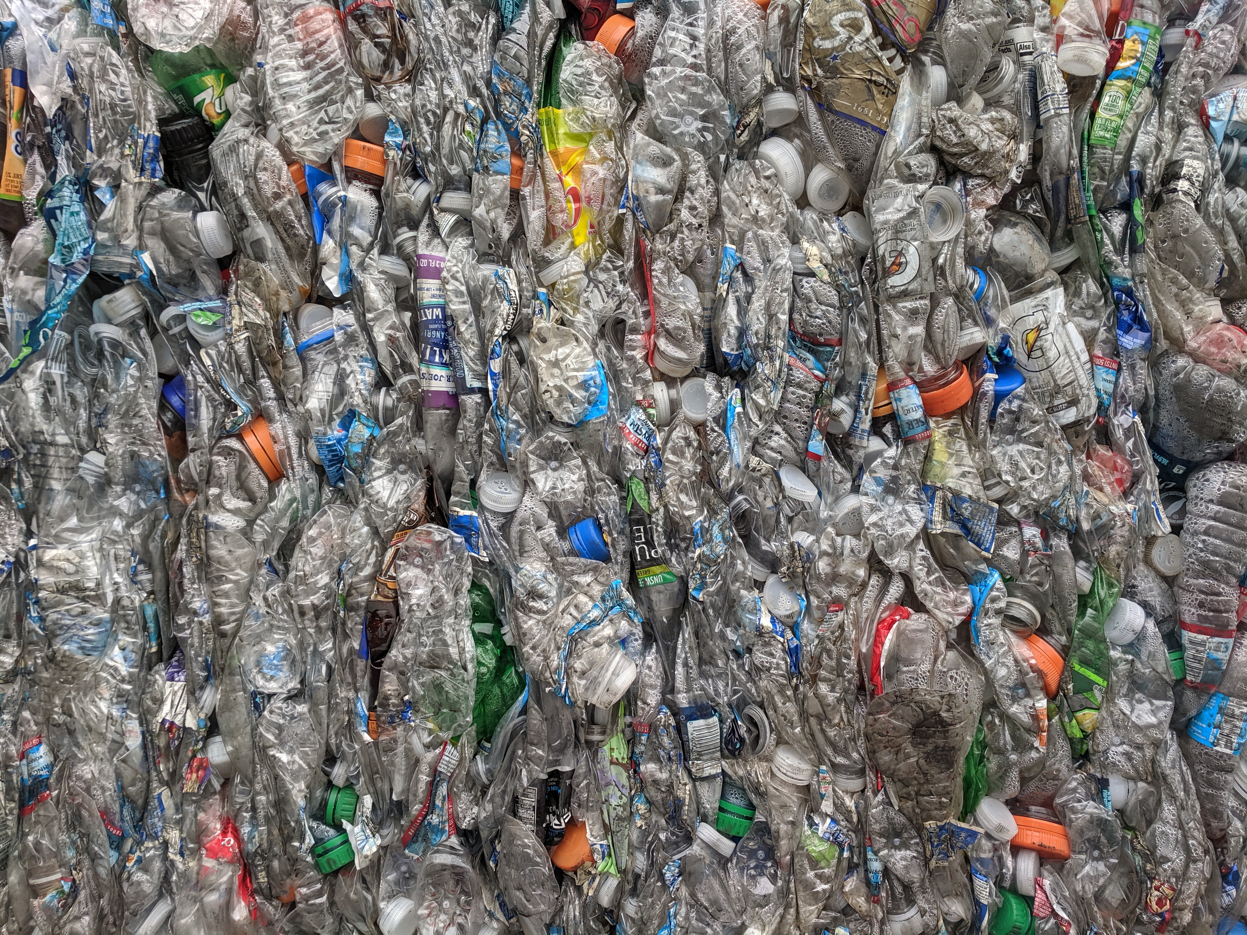 Bales of compressed discarded plastic bottles, photographed close up.